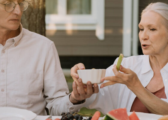 older couple sat together eating and drinking