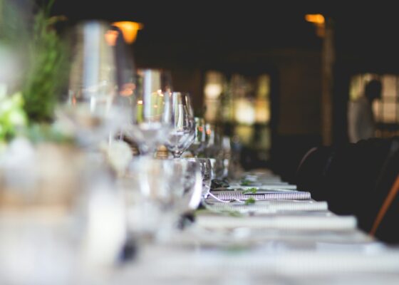 a table with glasses and plates on welcoming guests dressed by employees who work with a catering staffing agency