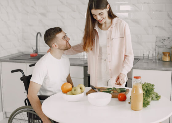 a man and woman at a table preparing vegetables