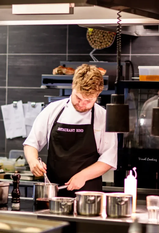 a cook in a modern kitchen preparing a meal