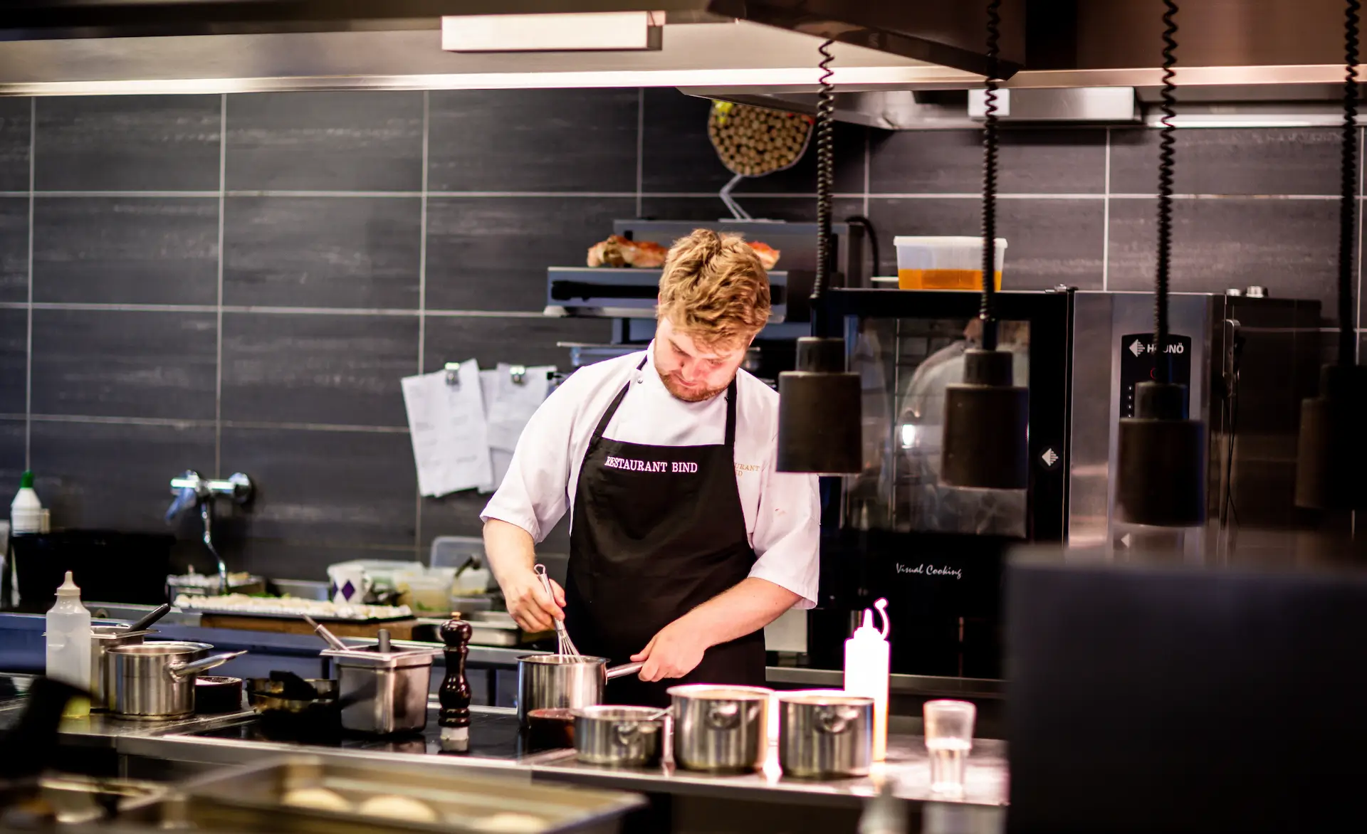 a cook in a modern kitchen preparing a meal