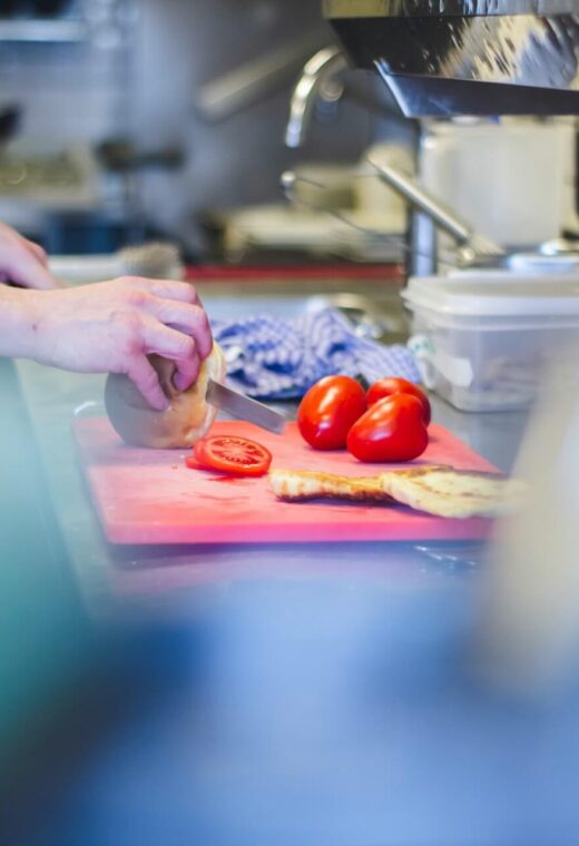 image showing a caterer chopping up tomatoes in a kitchen. wondering what catering in a care home is like? read more
