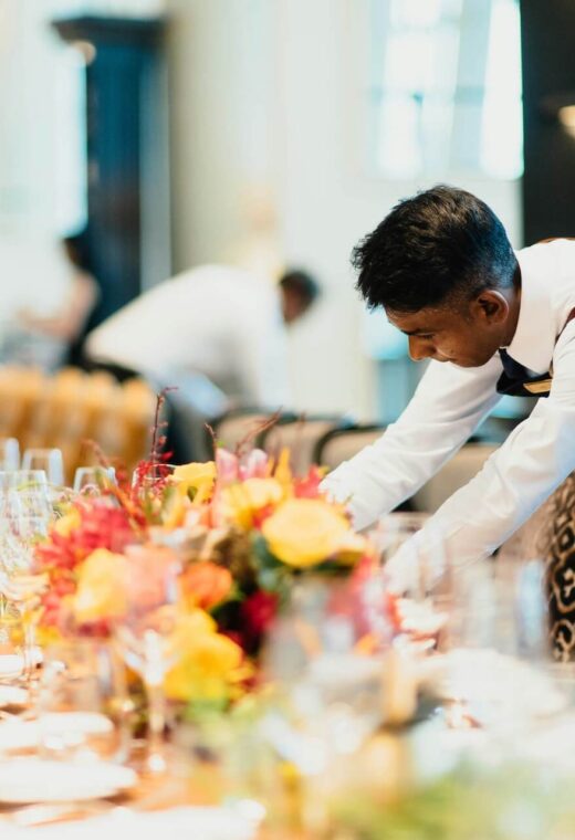 a staff member setting a table illustrating the advantages of using a catering staffing agency