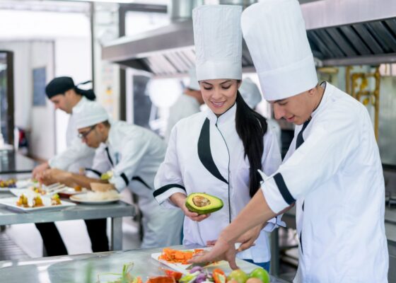 Chefs preparing food in a kitchen showing a chef staffing agency vs recruitment agency