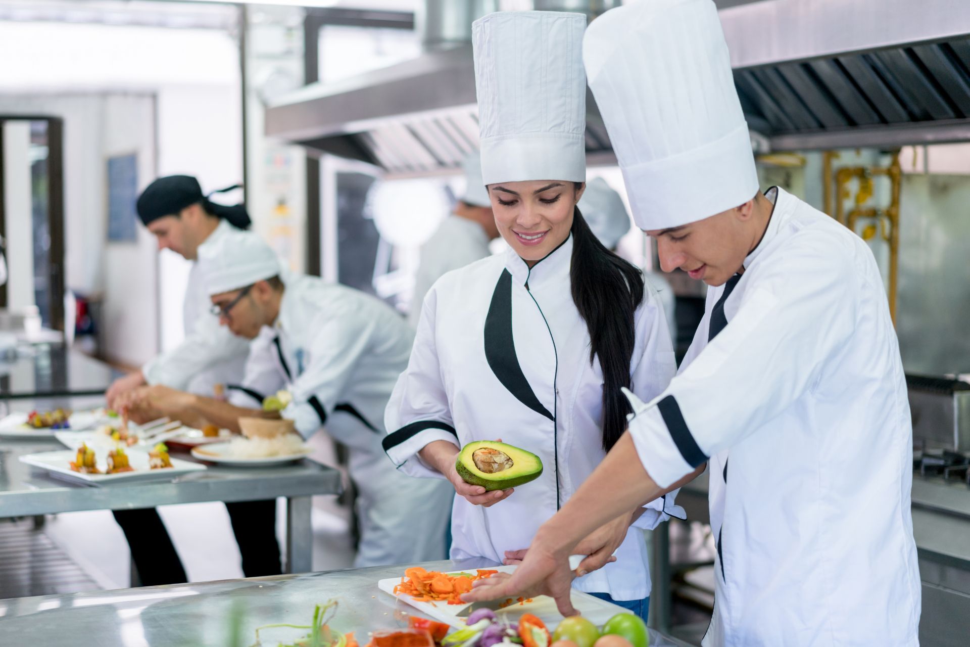 Chefs preparing food in a kitchen showing a chef staffing agency vs recruitment agency